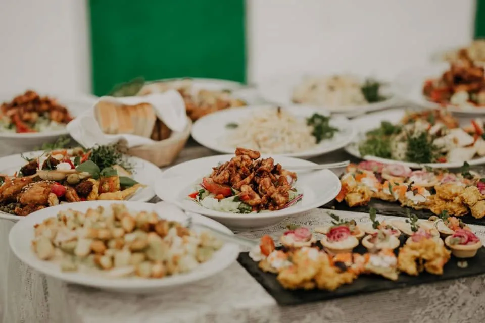 Svinību galds ar salātiem, ceptu vistu un uzkodām uz šīfera plates